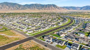 Aerial view of property and surrounding area with nearby suburban area and mountains