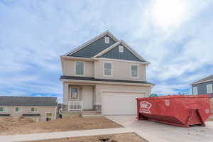 Craftsman inspired home with a garage, concrete driveway, board and batten siding, stone siding, and covered porch