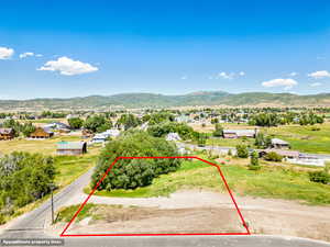 Aerial view of property's location with property parcel outlined and a mountainous background