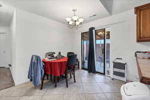 Dining room with a chandelier and light tile patterned floors