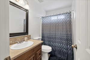 Bathroom featuring vanity, backsplash, and curtained shower