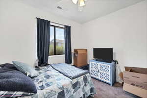 Carpeted bedroom featuring ceiling fan