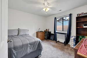 Carpeted bedroom featuring ceiling fan and baseboards