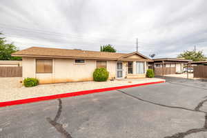 Ranch-style house featuring a shingled roof and stucco siding