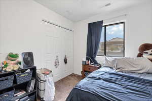 Bedroom featuring light carpet and a closet