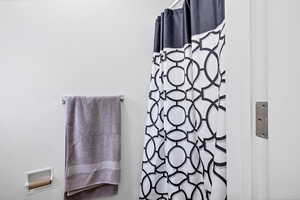 Bathroom view of a shower with shower curtain