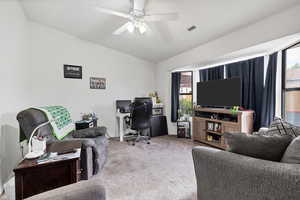 Carpeted office space featuring plenty of natural light and a ceiling fan