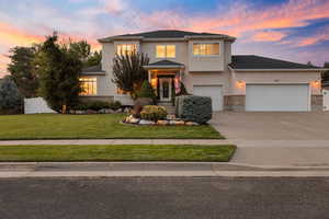Traditional-style home featuring concrete driveway, stucco siding, and a garage