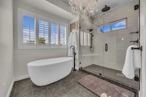 Bathroom featuring a freestanding bath, a shower stall, and tile patterned floors