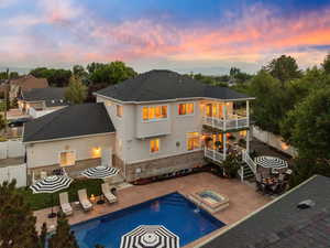 Back of property featuring a patio area, a fenced backyard, stucco siding, brick siding, and a pool with connected hot tub