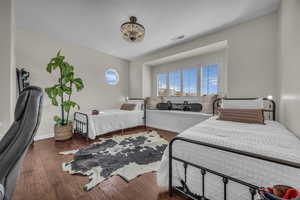 Bedroom featuring dark wood-type flooring and a chandelier