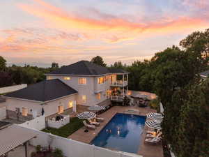 Back of property featuring a fenced backyard, a balcony, and a patio area