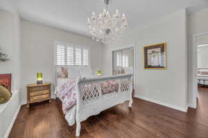 Bedroom with dark wood finished floors, a closet, and a chandelier