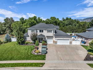 View of front of home with concrete driveway, stucco siding, a gate, and roof with shingles