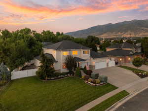 View of front facade with concrete driveway, stucco siding, a mountain view, and a garage