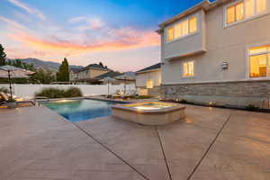 View of pool featuring a patio area, a fenced backyard, and a pool with connected hot tub