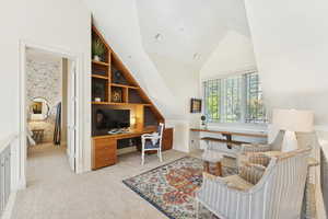 Office featuring built in shelves, high vaulted ceiling, and light carpet