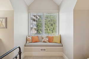 Unfurnished room featuring carpet and vaulted ceiling