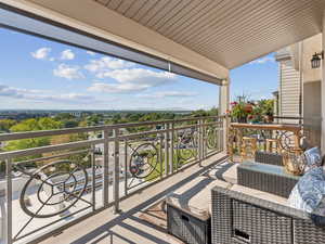 Balcony featuring view of wooded area