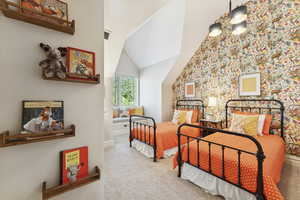 Carpeted bedroom with wallpapered walls and vaulted ceiling