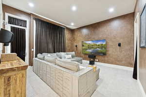 Home theater room with light colored carpet and recessed lighting