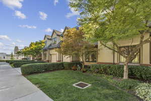 View of property exterior with a lawn and stucco siding