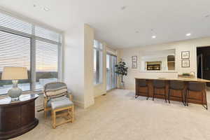 Bar with recessed lighting, light carpet, and light countertops