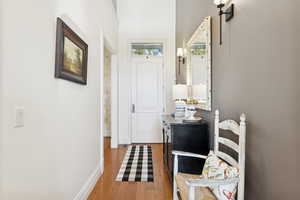 Hall with light wood-type flooring and baseboards