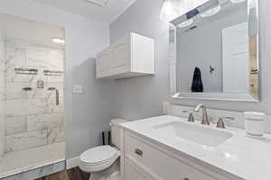 Bathroom featuring vanity, a shower stall, and dark wood-style floors