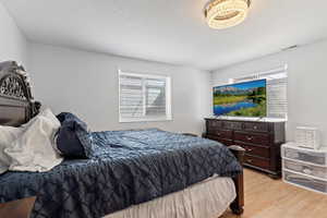 Bedroom with light wood-style flooring and a textured ceiling