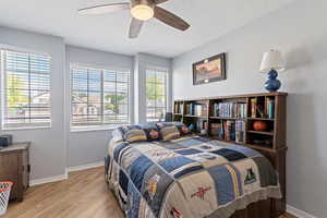 Bedroom with light wood-style floors and a ceiling fan