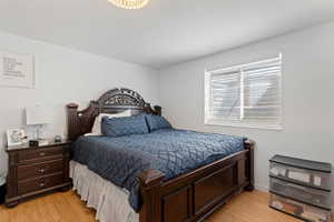 Bedroom featuring light wood finished floors and a textured ceiling