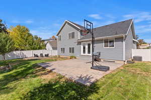 Rear view of house featuring a patio, a fenced backyard, and roof with shingles