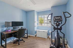 Home office featuring light wood-type flooring and a ceiling fan