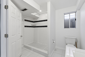 Bathroom with light tile patterned floors and a stall shower