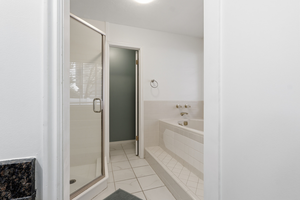 Bathroom featuring a shower stall, a bath, and light tile patterned floors