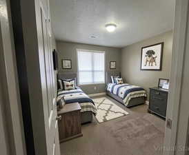 Bedroom featuring a textured ceiling and dark carpet