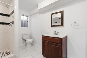 Bathroom with vanity, a stall shower, and light tile patterned flooring