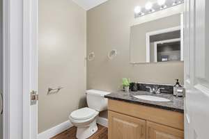 Half bathroom with vanity and dark wood-style flooring
