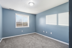 Carpeted empty room with baseboards and a textured ceiling