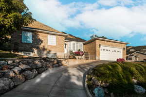 View of front of home featuring brick siding, concrete driveway, and an attached garage