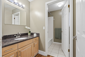 Bathroom featuring vanity,  shower combination, and light wood finished floors