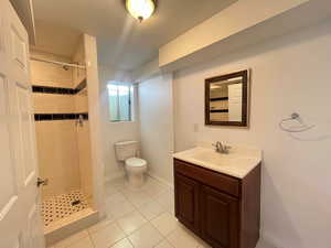 Full bath with light tile patterned flooring, vanity, and a stall shower