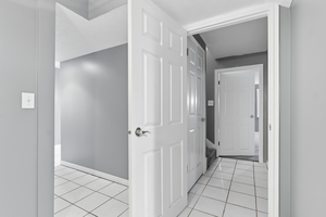 Hall featuring light tile patterned floors and baseboards