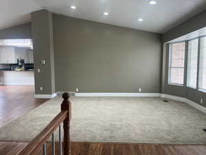 Unfurnished room with light wood-type flooring, lofted ceiling, and recessed lighting