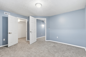 Unfurnished bedroom with a textured ceiling and carpet