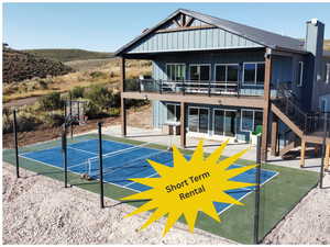Rear view of property with board and batten siding, a patio, stairway, and a deck
