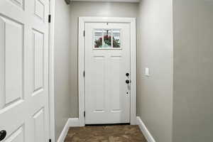 Entryway with baseboards and stone finish floors