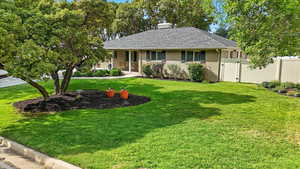 Ranch-style home with brick siding, a shingled roof, a chimney, a gate, and a porch