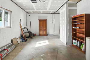 Garage featuring concrete block wall and a garage door opener